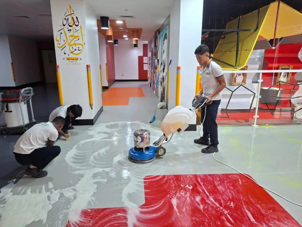 Professional cleaners performing deep cleaning services on a commercial floor in Dubai, ensuring a spotless, hygienic environment.