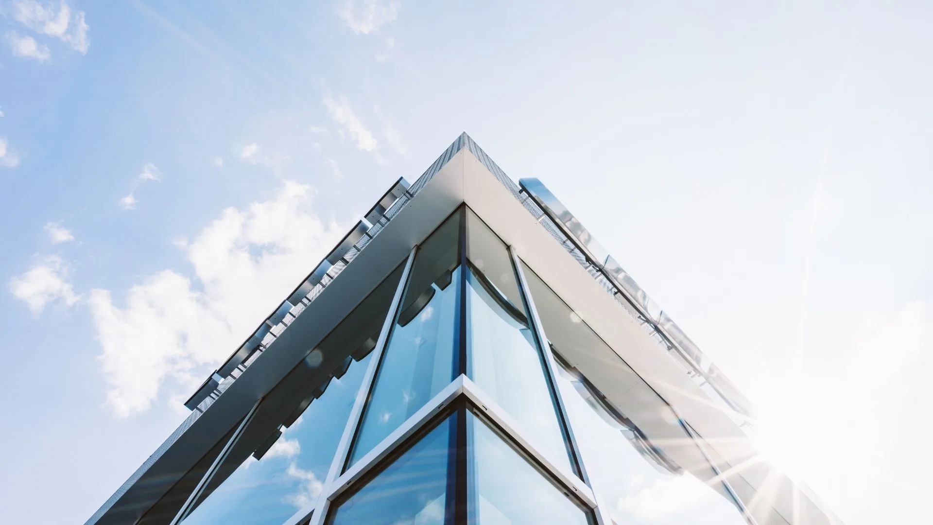 Villa cleaning services 3 Modern villa glass exterior reflecting the sky, ideal for villa cleaning services.